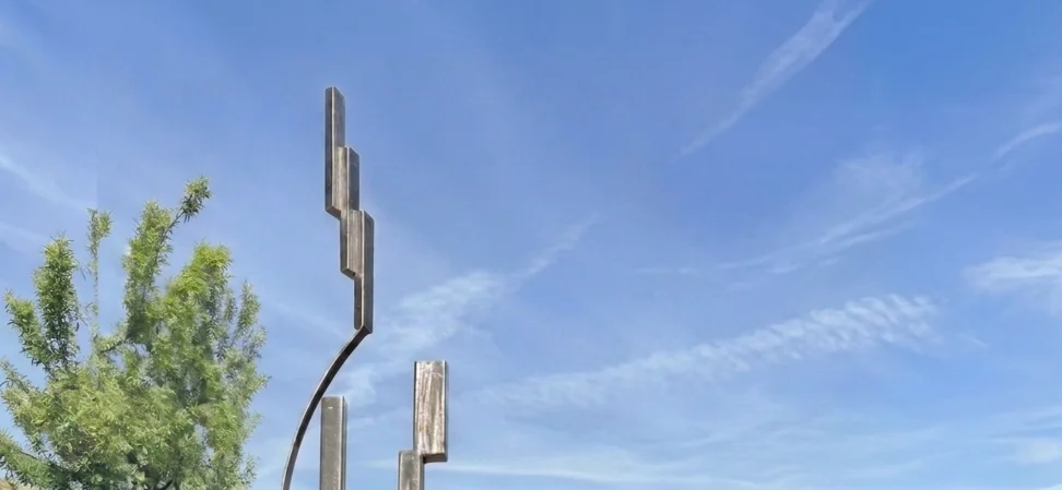Vertical monumental steel sculpture with ascending architectural forms rising into the sky, designed as a landmark public art and placemaking element for civic spaces, mixed-use developments, and corporate environments by sculptor Michael Herold.